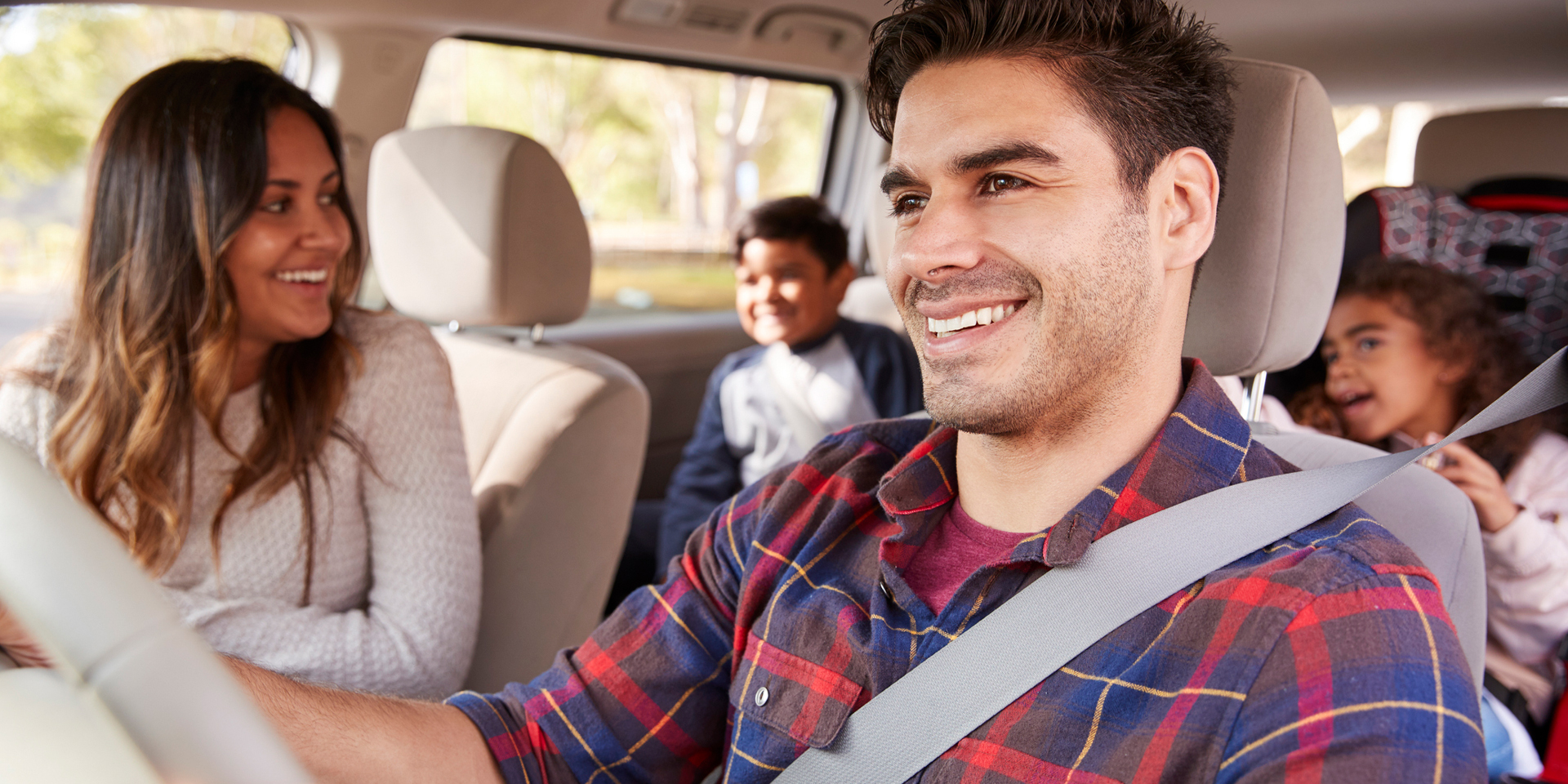 A family in a car laughing and playing