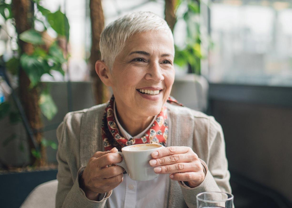 A Midwest Checking customer who is enjoying a cup of coffee in a restaurant 