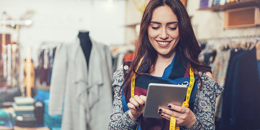 A woman who owns an online clothing store uses a tablet to explore business banking deposit rates online