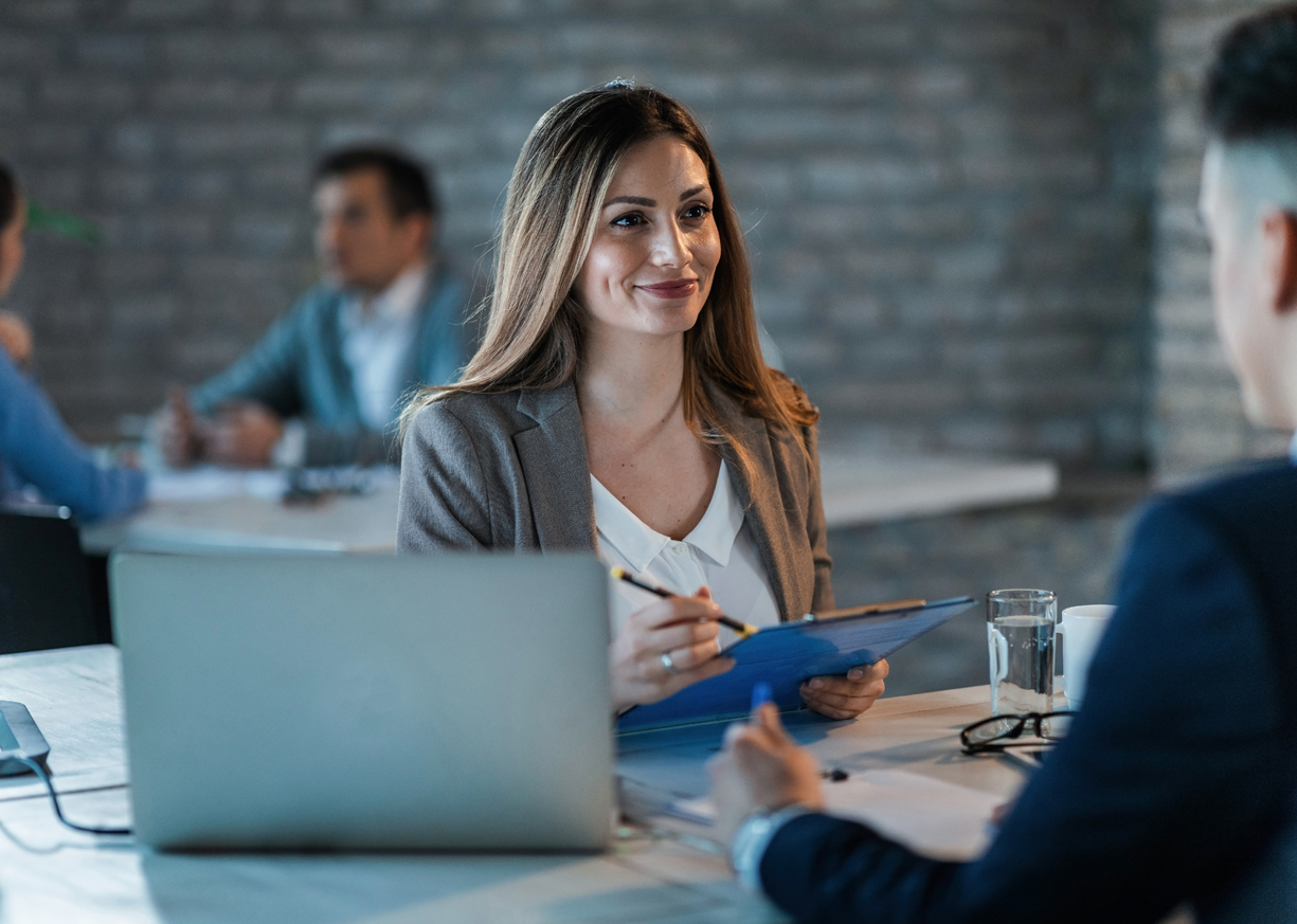 Two colleagues are meeting in a coffee shop and discussing the best checking account options for their business