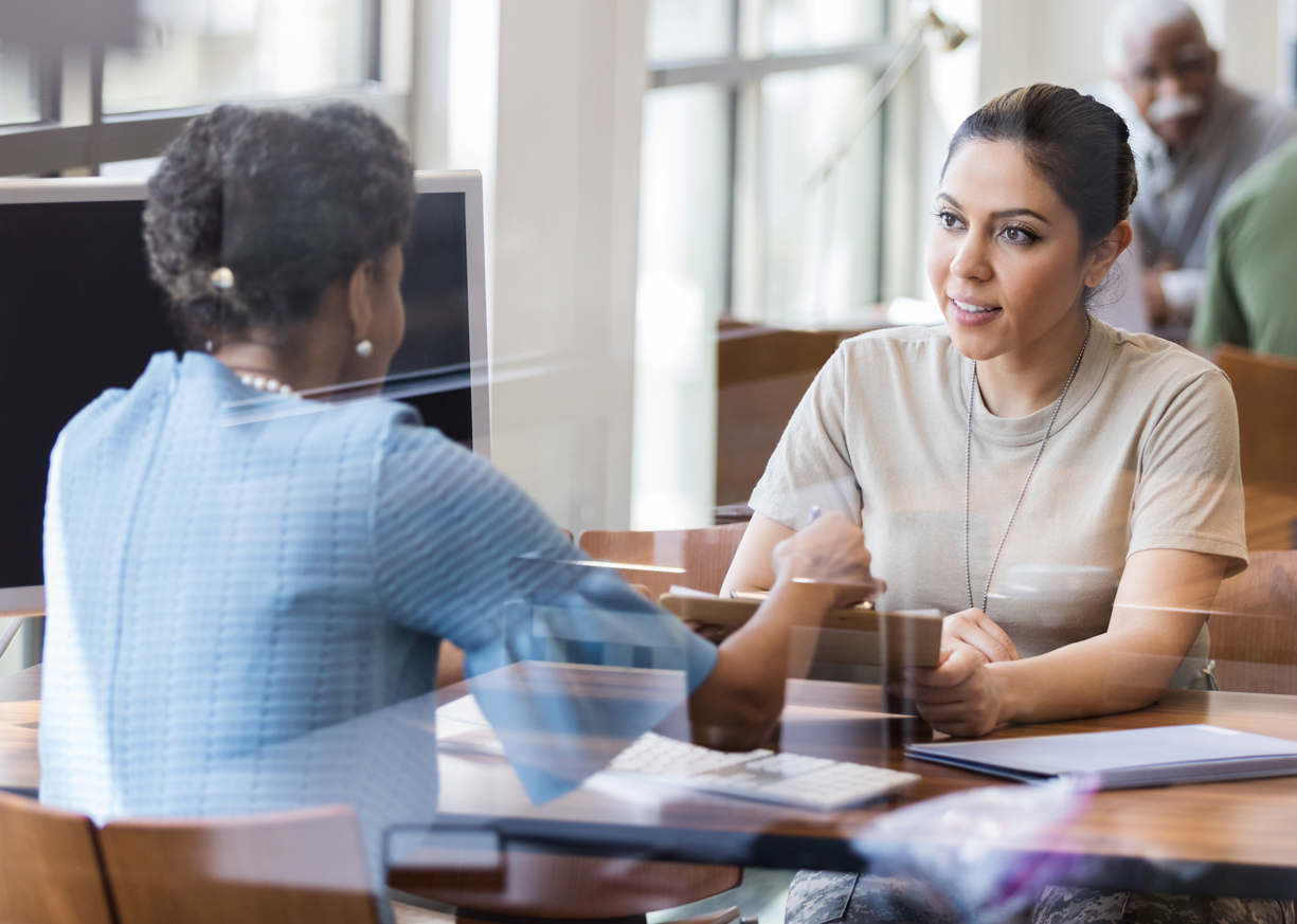 A businesswomen works with her banker to open a Business Checking account