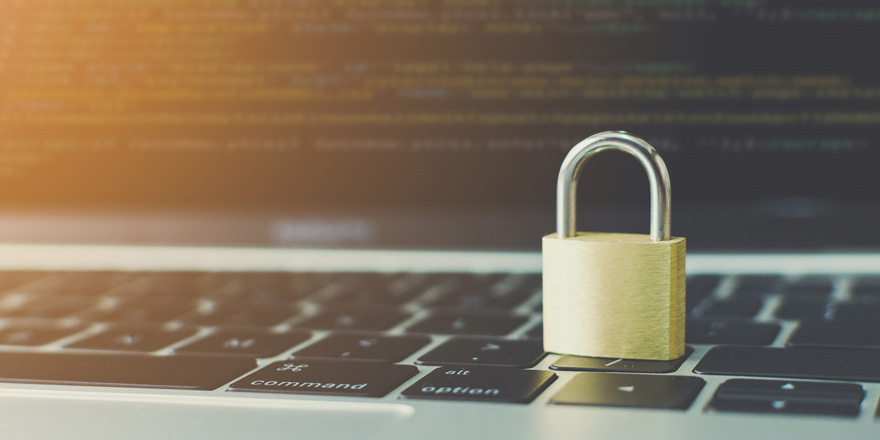 Close up of a padlock sitting on a laptop as a symbol of protecting your business from fraud