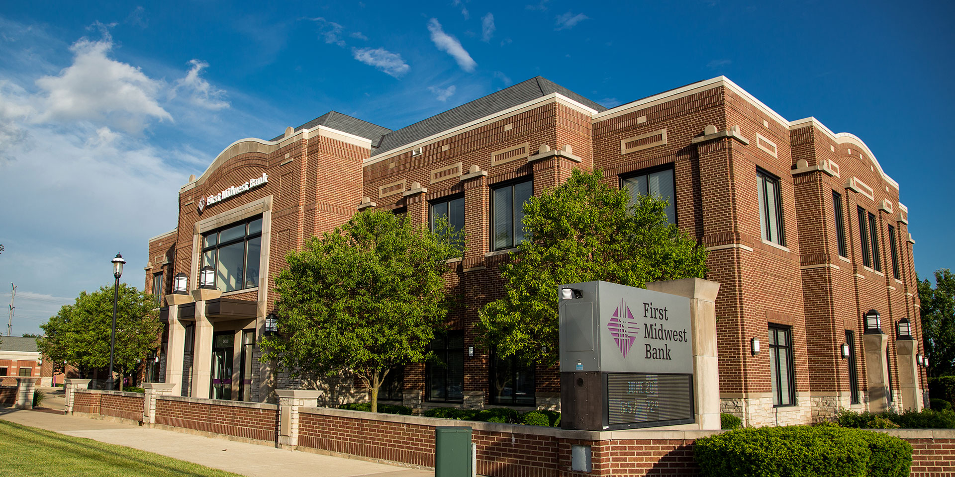A building exterior photo of a First Midwest Bank location on a sunny day