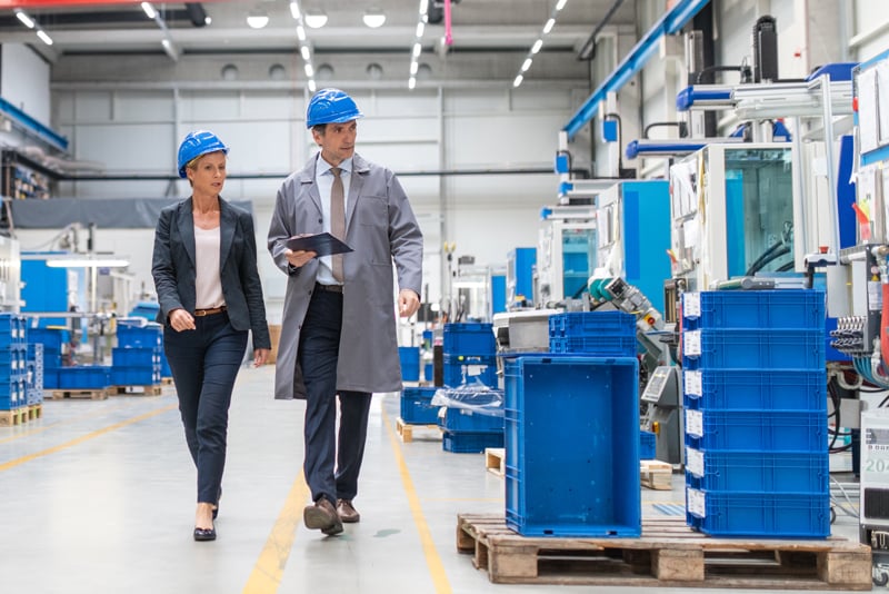 Business owner and colleague walking a production floor.