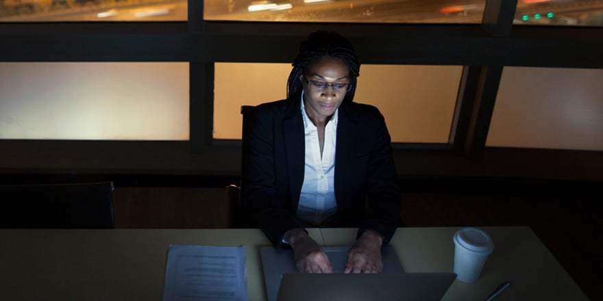 A businesswoman on her laptop researches the best loan syndications for her company