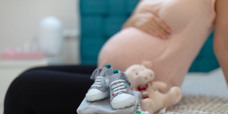 An expectant mother is sitting in the new baby’s room and has reviewed personal account and loan rates