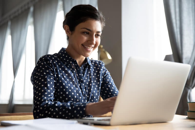 Young lady accessing her account on her laptop.