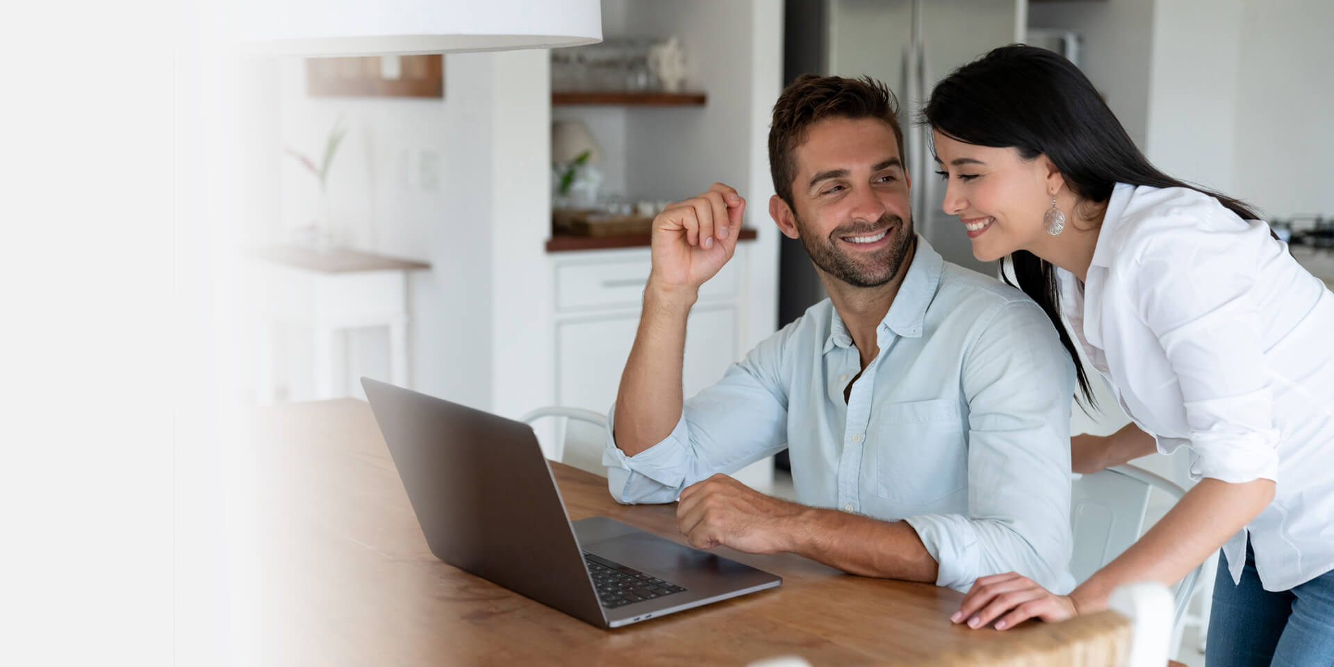 A couple paying a loan payment online from their laptop