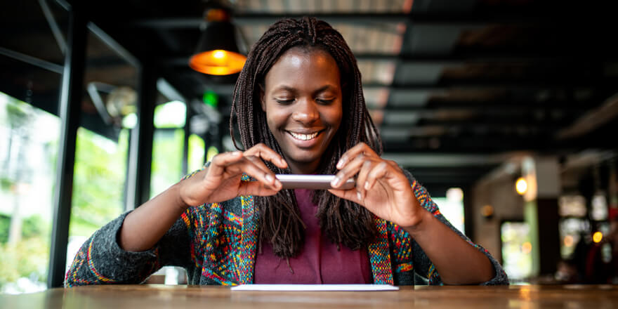 Young woman taking a photo of her check from her mobile device